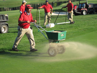 A photo of golfing green being fertilized.
