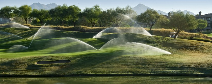 A photo of a modern golf course irrigation system putting down some  water.